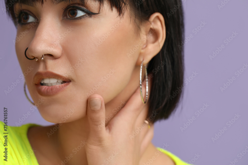 Stylish young woman with nose piercing on lilac background Stylish young woman with nose piercing on lilac background