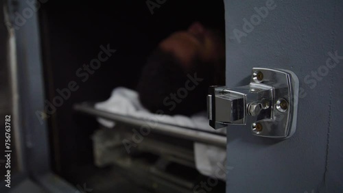 Zoom out from morgue handle to corpse and doctor