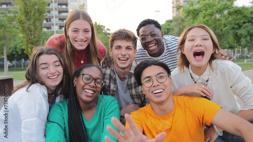 Big group of young adult real people greeting, smiling and having fun at vacations. Happy friends laughing. University teenage students waving hands on a social gathering Multiracial teenagers meeting photo