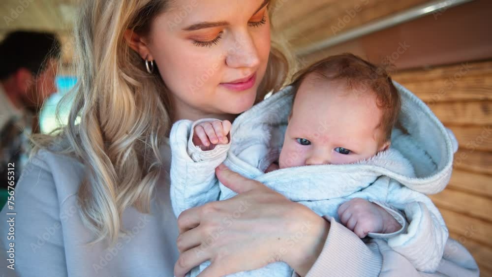 A mother affectionately kisses her baby's, enveloping the child in a soft blanket in camper van. A mother affectionately kisses her baby's, enveloping the child in a soft blanket in camper van.