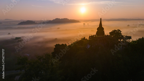 Beautiful sunrise with pagoda on the top of cliff, morning mist at Khao Na Nai Luang Dharma Park, Surat Thani province, Thailand