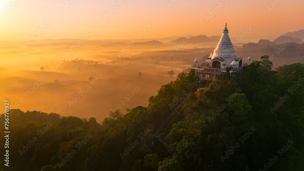 Beautiful sunrise with pagoda on the top of cliff, morning mist at Khao Na Nai Luang Dharma Park, Surat Thani province, Thailand