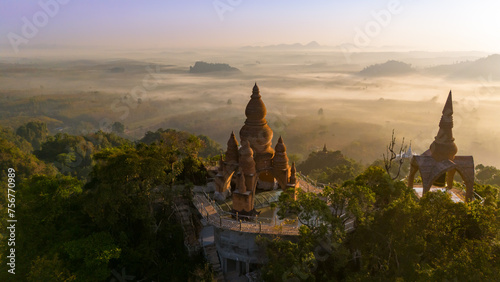 Beautiful sunrise with pagodas on the top of cliff, morning mist at Khao Na Nai Luang Dharma Park, Surat Thani province, Thailand