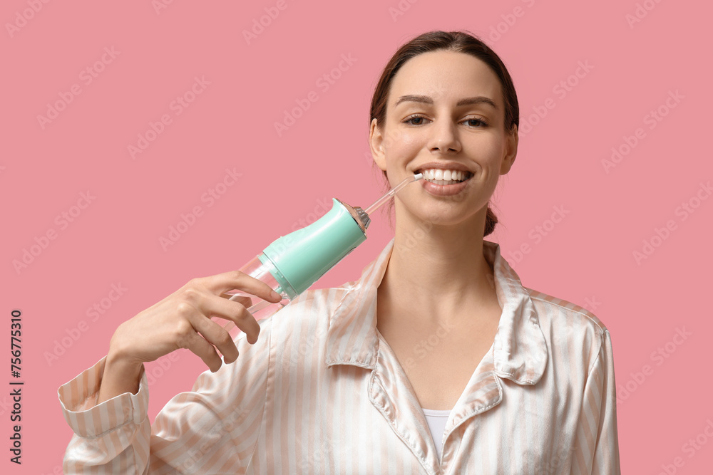 Beautiful young woman with oral irrigator on pink background Beautiful young woman with oral irrigator on pink background