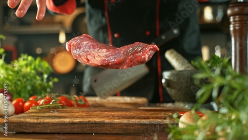 Chef Throwing Raw Beef Steak on Wooden Cutting Board. © Jag_cz
