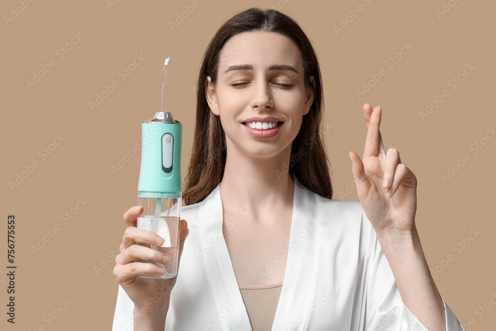 Beautiful young woman with oral irrigator on brown background Beautiful young woman with oral irrigator on brown background