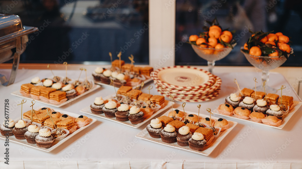 Beautifully decorated catering banquet table with different food snacks and appetizers with sandwich, caviar, fresh fruits on corporate christmas birthday party event or wedding celebration.