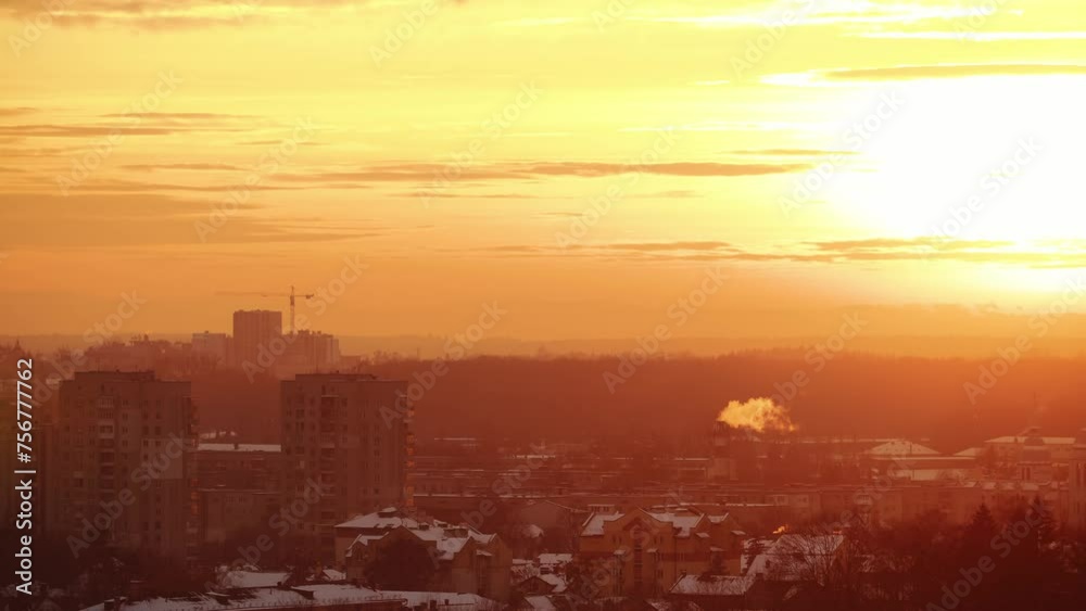 A golden sunset bathes a wintry cityscape, with smoke rising from a distant stack against a tranquil evening sky. A golden sunset bathes a wintry cityscape, with smoke rising from a distant stack against a tranquil evening sky.