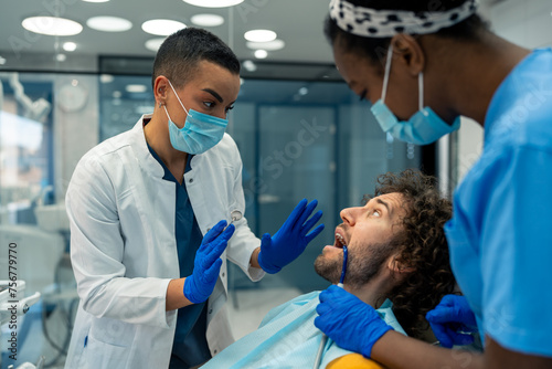 Fotografía Female dentist reassuring upset male patient at dentist's chair