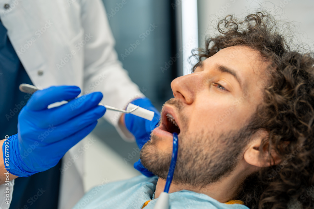 Man feeling uncomfortable during dental procedure at dentist's office. Man feeling uncomfortable during dental procedure at dentist's office.