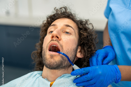 Male patient at the dentist s for a teeth check.