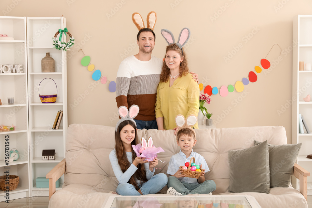 Fototapeta premium Parents and children with Easter eggs and cake in living room