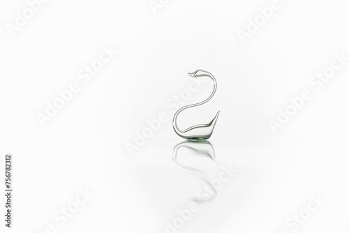 Glass swan with reflection is isolated on white background. Glass swan figurine. Perfect symbol of forever love - swan made of transparent glass. 