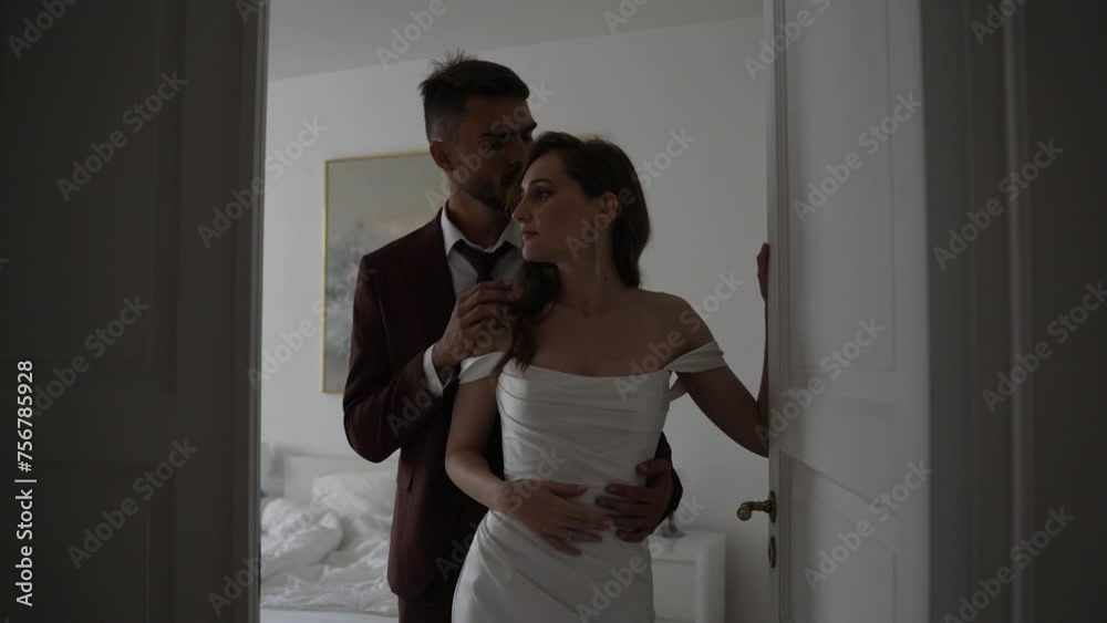 Bride and groom in wedding attire pose for flash photography in doorway Bride and groom in wedding attire pose for flash photography in doorway