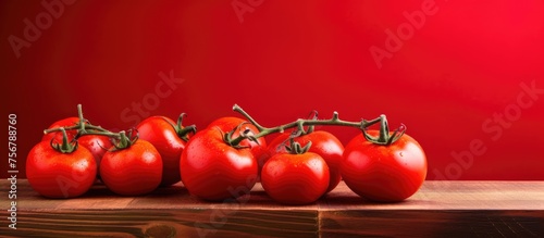 A pile of fresh, ripe tomatoes from a local farm is beautifully displayed on a wooden table. These vibrant fruits are a staple food and superfood, packed with nutrients and flavor © 2rogan