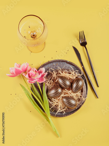 Table place setting, empty glass, Pink tulips and festive easter decor