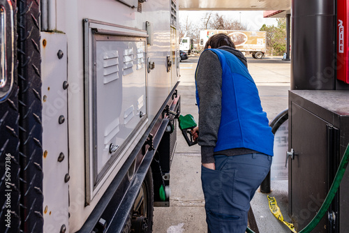 Bild auf Leinwand Man putting diesel fuel in truck with green handled pump at gas station