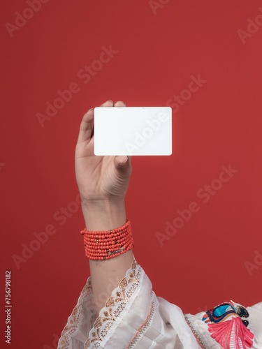 kichwa woman's hand with red handles holding a credit card photo
