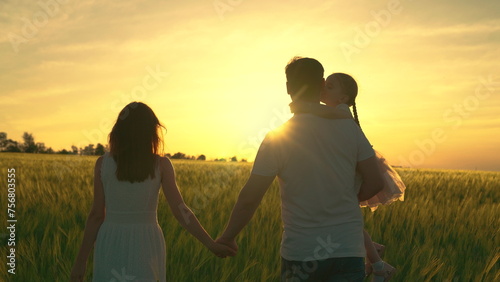 Active family, Mom dad and child are walking together, farmers with baby in their arms walks through wheat field. Mother, father, little daughter play, enjoy nature outdoors, dream. Go Everywhere