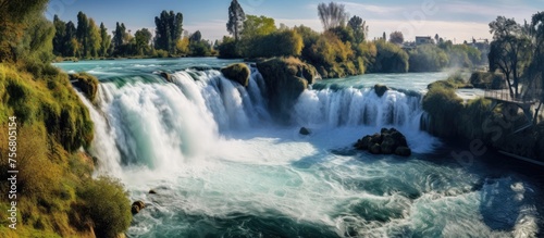 A stunning waterfall is situated in the center of a river, with lush trees surrounding it. This picturesque fluvial landform is a mustsee for nature lovers while traveling