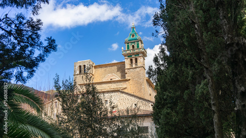Carthusian Monastery of Valldemossa Peeking Through Verdant Trees in Mallorca © juanjo