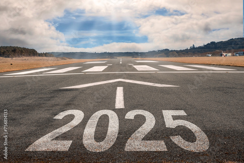 White arrow on a small asphalt air plane runway and sign 2025. Cloudy sky with small blue opening in the middle. Sun rays and flare. Take off and opportunity sizing concept.