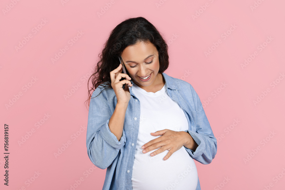 Smiling expecting lady talking on phone with her doctor Smiling expecting lady talking on phone with her doctor