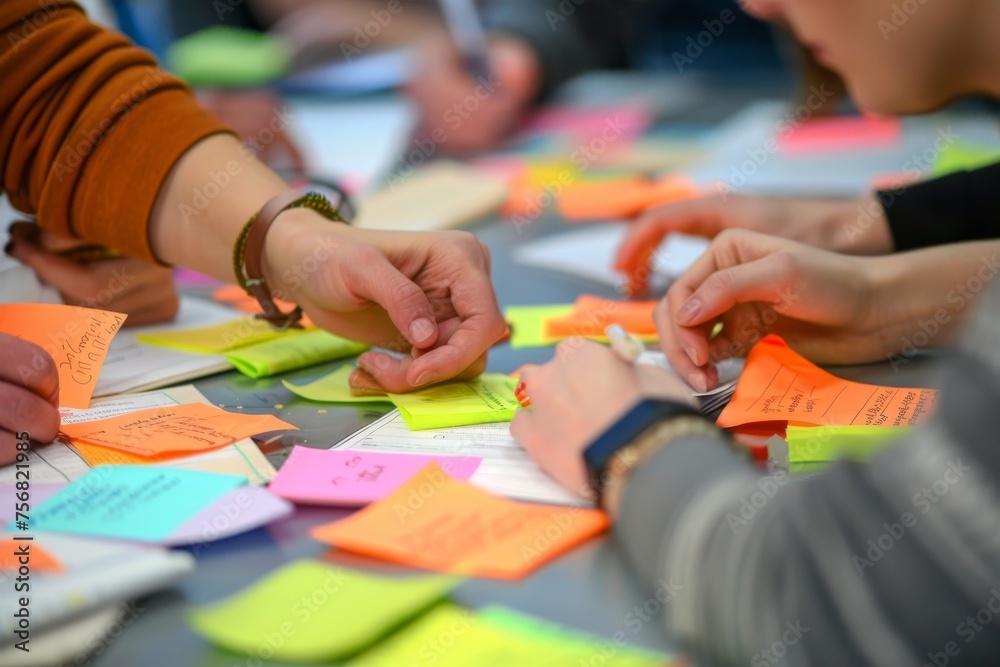 Individuals engaging in a brainstorming session with colorful sticky notes on a table