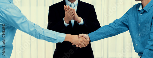 Photos Corporate attorney applaud as business people seal a successful deal or agreement with handshake, celebrating mutually beneficial acquisition