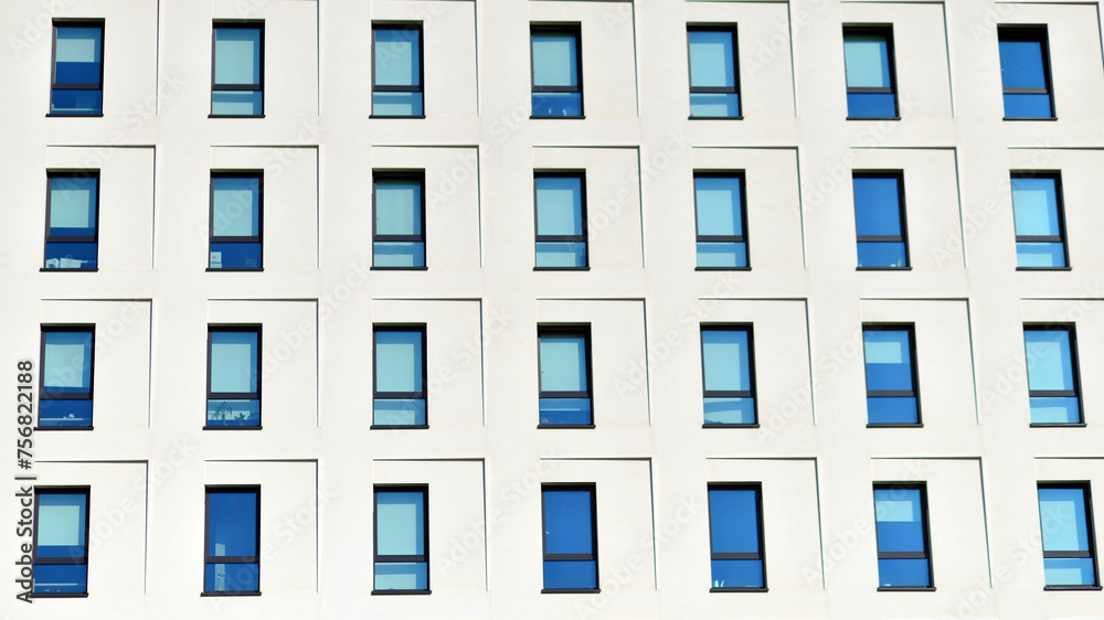 View of a white modern apartment building. Perfect symmetry with blue sky. Geometric architecture detail modern concrete structure building. Abstract concrete architecture. 