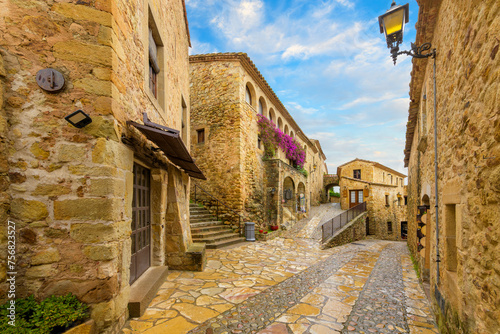 The picturesque cobblestone streets full of shops and cafes in the medieval Spanish town of Pals, Spain, in the Costa Brava region of Catalonia. photo