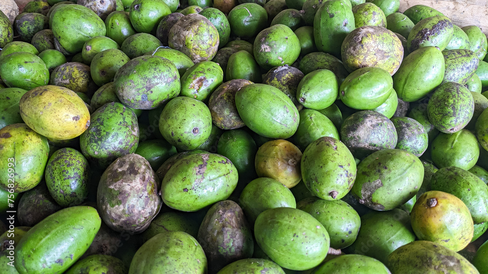 A diverse mix of ambarella fruits, showcasing different stages from green to ripe yellow. A diverse mix of ambarella fruits, showcasing different stages from green to ripe yellow.