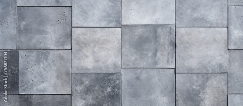 A close up of a rectangular grey tile wall made of composite material. The flooring features a symmetrical pattern with tints and shades, creating parallel lines