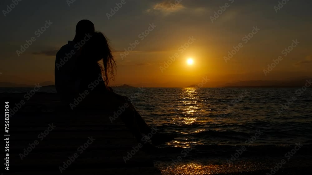 Family admire colorful fiery sunset. A child and her father enjoy the time together on the pier during nightfall time. Family admire colorful fiery sunset. A child and her father enjoy the time together on the pier during nightfall time.