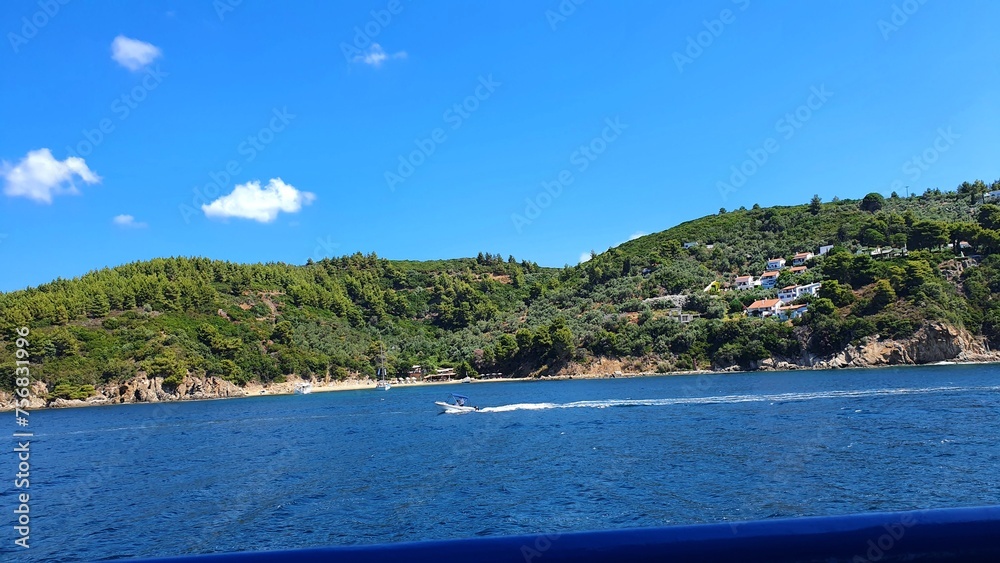 Motorówka na morzu greckim na tle wyspy i błękitnego nieba