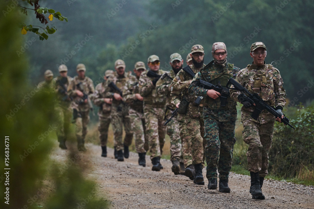 An elite military unit, led by a major, confidently parades through dense forest, showcasing precision, discipline, and readiness for high-risk operations - obrazy, fototapety, plakaty 