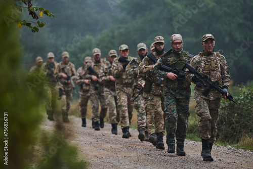 An elite military unit, led by a major, confidently parades through dense forest, showcasing precision, discipline, and readiness for high-risk operations photo
