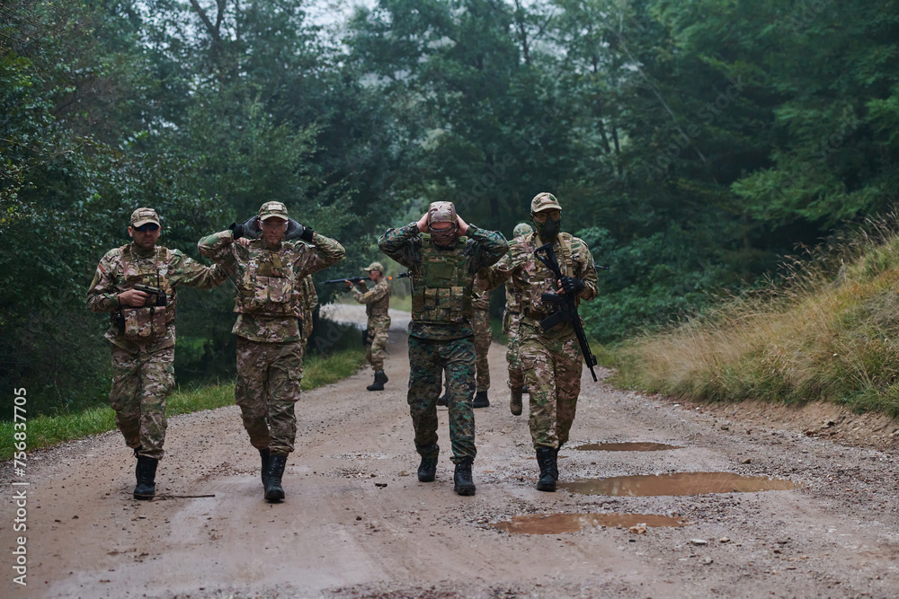 Fototapeta premium A group of elite soldiers leads captives through a military camp, showcasing a tense atmosphere of detention and security operations
