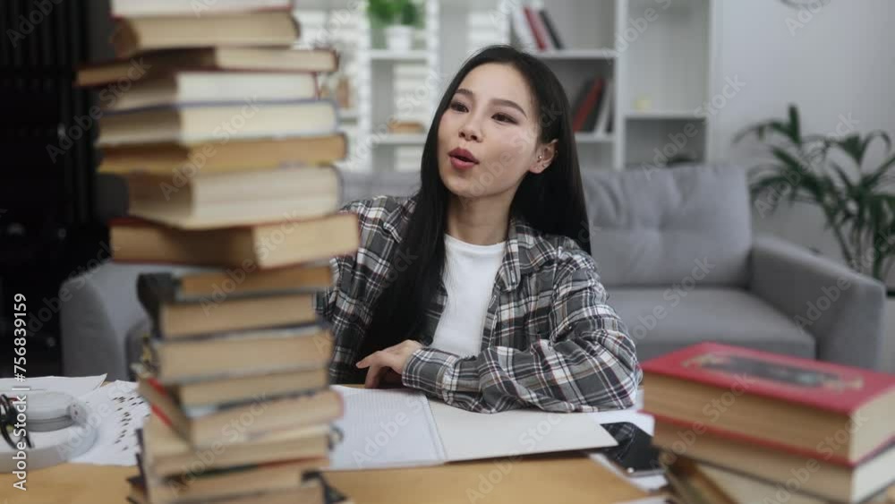 Happy smiling asian woman student looking from behind large pile of books with enthusiastic face while studying preparing for exams at home Effective education Happy smiling asian woman student looking from behind large pile of books with enthusiastic face while studying preparing for exams at home Effective education