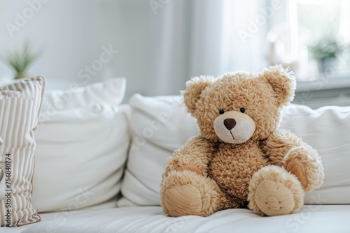 Soft plush teddy bear on a white couch © InfiniteStudio