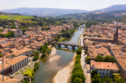 Picturesque drone view of Limoux summer cityscape looking out over ghotic cathedral on bank of river Aude , France.