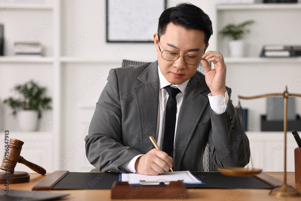 Notary writing notes at wooden table in office Notary writing notes at wooden table in office