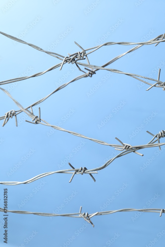 Metal barbed wire on light blue background Metal barbed wire on light blue background