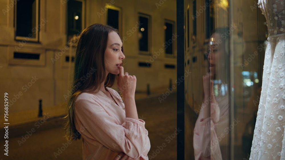Girl watching bridal dress on mannequin standing store showcase close up. Girl watching bridal dress on mannequin standing store showcase close up.