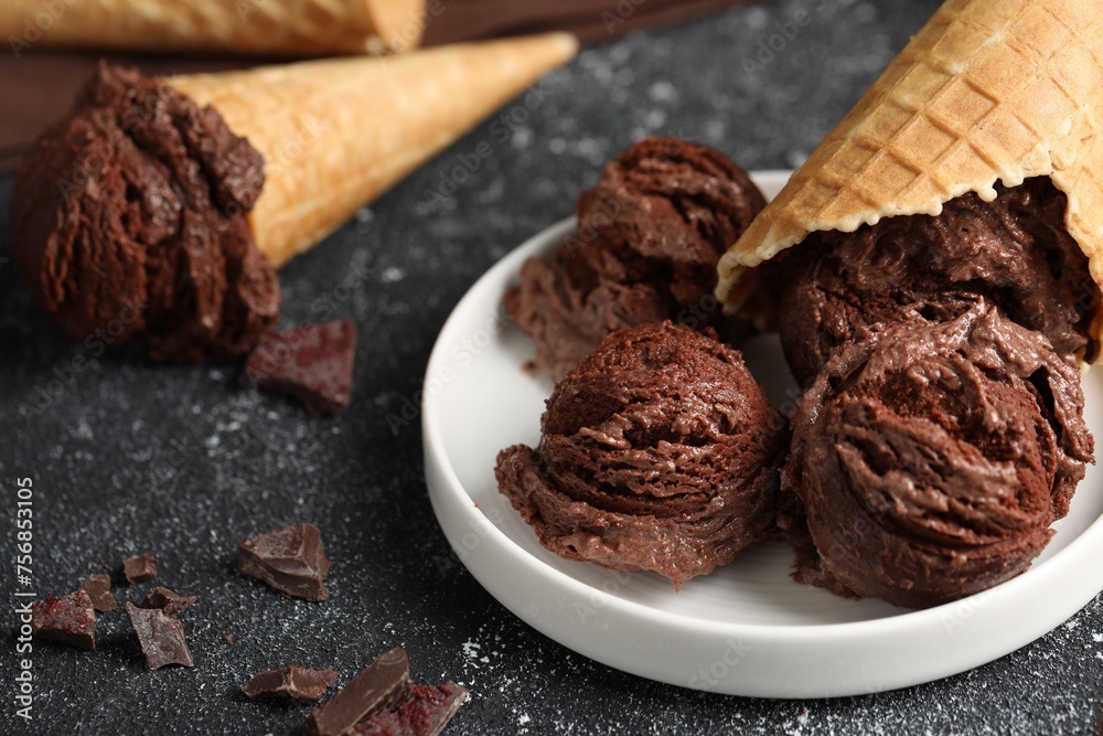 Tasty ice cream scoops, chocolate crumbs and waffle cones on dark textured table, closeup Tasty ice cream scoops, chocolate crumbs and waffle cones on dark textured table, closeup