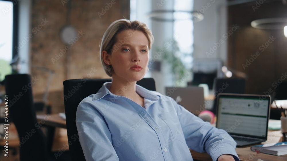 Fototapeta premium Portrait confident businesswoman sitting modern office. Lady boss looking camera