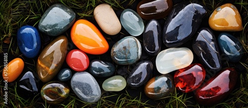 An array of vibrant rocks adorning a verdant meadow, creating a natural artwork of colors and patterns. The stones sit in a circular formation, enhancing the beauty of the landscape