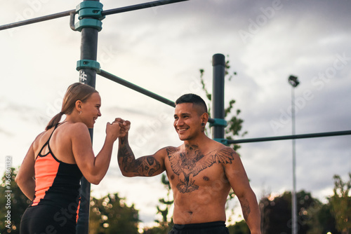 interracial couple training outdoors. fist bumping