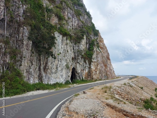 Photo of Street in Lampa Strait area, Natuna Island. The road is on a rock wall and borders the South China Sea. A scenic road leads to the harbor.