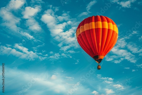 A hot air balloon is floating in the sky above a blue and white sky